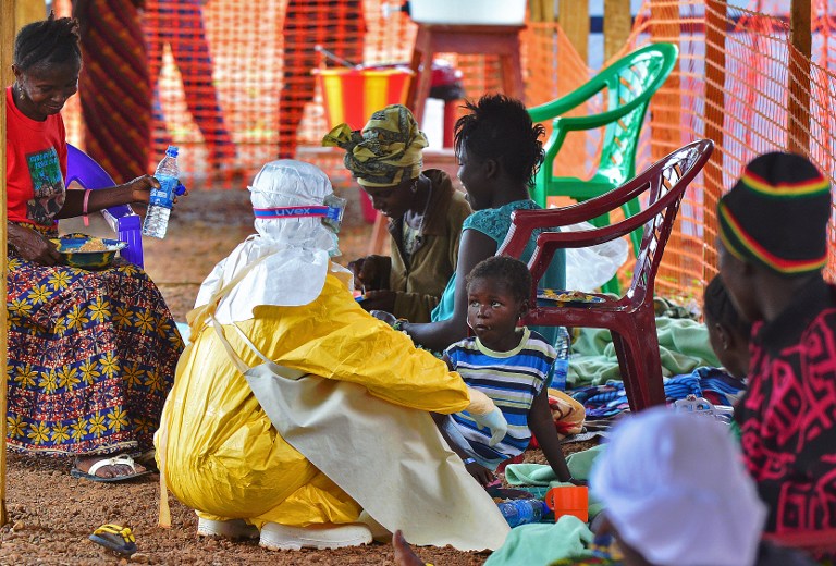 DAILY STRUGGLE. An Medecins Sans Frontieres (Doctors Without Borders) medical worker feeds an Ebola child victim at an MSF facility in Kailahun, Sierra Leone, on August 15, 2014. Carl de Souza/AFP