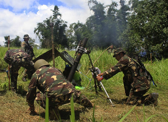 FIGHTING TERROR. This photo taken on May 29, 2016 shows Philippine soldiers firing mortar rounds toward enemy positions from Butig town, Lanao del Sur province in the southern Philippine island of Mindanao. Photo by Richele Umel/AFP 