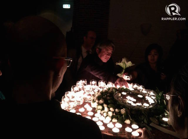 MENYALAKAN LILIN. Para peserta sidang IPT 1965 menyalakan lilin untuk menghormati korban tragedi 1965 di Den Haag, Belanda. Foto oleh Rika Theo/Rappler  