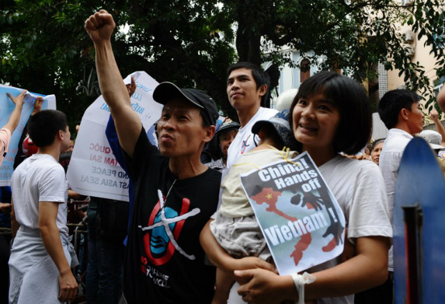 RESIST. This picture taken on July 8, 2012 shows Tran Thi Nga (R) holding her son and an anti-China poster as she takes part in an anti-China rally in Hanoi. File photo by Hoang Dinh Nam/AFP 