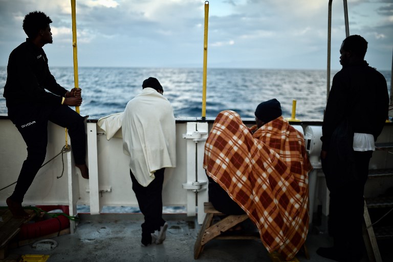 AQUARIUS. In this file photo taken on May 14, 2018 migrants look at the coastline as they stand aboard the French rescue ship MV Aquarius, off the coast of Sicily. Photo by Louisa Gouliamaki/AFP 