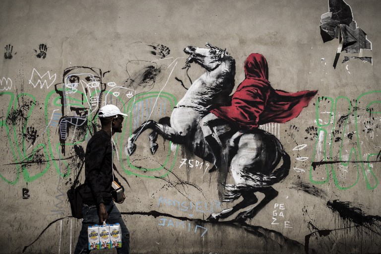 PARIS. A man walks past a recent artwork by street artist Banksy in Paris on June 25, 2018. Photo by Philippe Lopez/AFP 