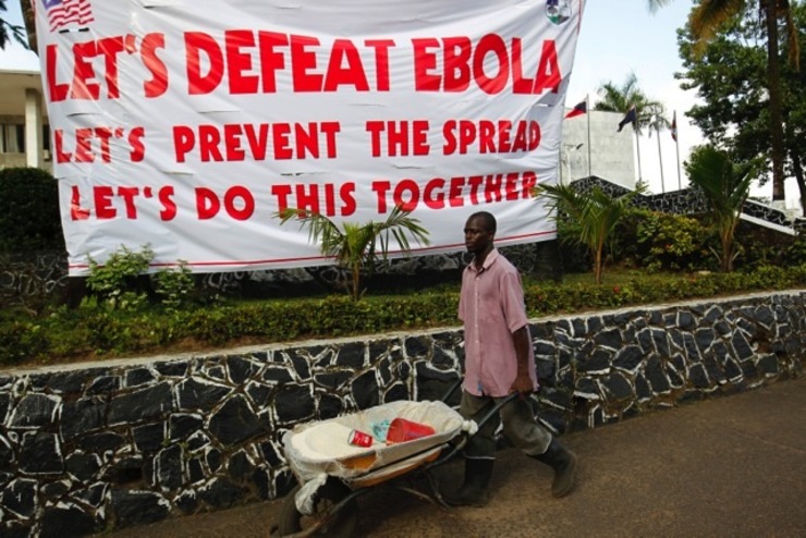 'DEFEAT EBOLA.' A Liberian man walks past an Ebola information poster as a measure to curb the spread of the Ebola virus in Monrovia, Liberia 16 October 2014. File photo by Ahmed Jallanzo/EPA