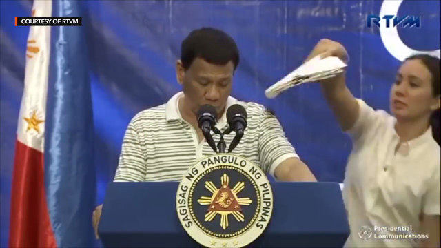 SWATTING BUGS. An aide attempts to swat a cockroach from President Rodrigo Duterte's shoulder as he addresses a crowd in Bohol on May 8, 2019. Screenshot from RTVM video feed. 