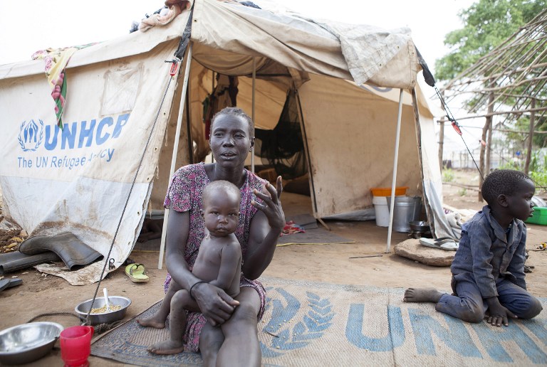 ESCAPING WAR. A woman and her children displaced by fighting in South Sudan sit outside her tent at the Kule camp for Internally Displaced People at the Pagak border crossing in Gambella, Ethiopia, on July 10, 2014. Zacharias Abubeker/AFP