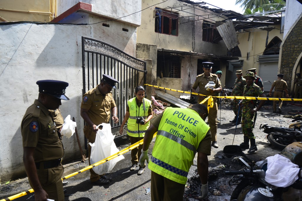 BOMBINGS. Sri Lankan security personnel and police investigators look through debris outside Zion Church following an explosion in Batticaloa in eastern Sri Lanka on April 21, 2019. Photo by Lakruwan Wanniarachichi/AFP 