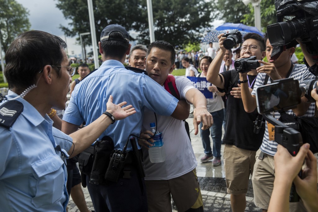 PROTEST. A pro-police demonstrator (C) is held back by police as he yells insults at anti-extradition protesters at a rally in support of police outside the Legislative Council in Hong Kong on June 30, 2019. Photo by Isaac Lawrence/AFP  