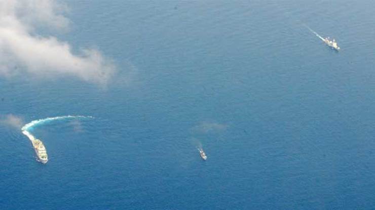 DWARFED BY CHINA. Two Chinese coast guard ships chase a small Philippine vessel (middle) in the West Philippine Sea (South China Sea). File photo by Jay Directo/AFP