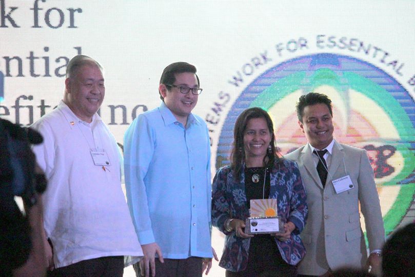 WINNER. Nanette Antequisa receives the first prize award at the DSEA Awards on behalf of EcoWEB. Photo from the EcoWEB Facebook page]  