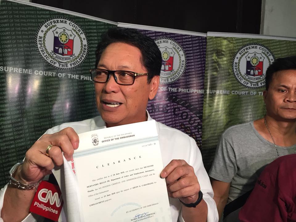 CLEARED. Labor Secretary Silvestre Bello III presents a recently-obtained Ombudsman clearance that states he no longer has pending cases before the Office of the Ombudsman. Photo by Lian Buan/Rappler 