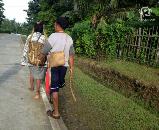 WIFE AND HUSBAND. In Hanunuo tradition, men walk behind women and carry less weight so they can easily attack in case danger strikes. Photo by Fritzie Rodriguez/Rappler   