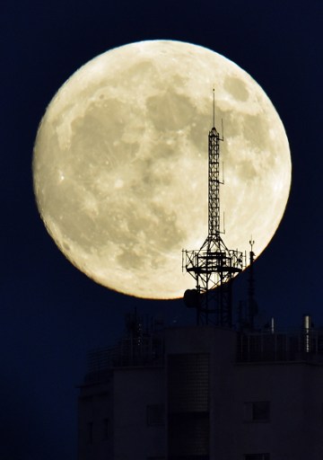 Penampakkan super moon dari salad satu gedung di Marid, Spanyol, Minggu (13/11). Foto oleh GERARD JULIEN/AFP 
