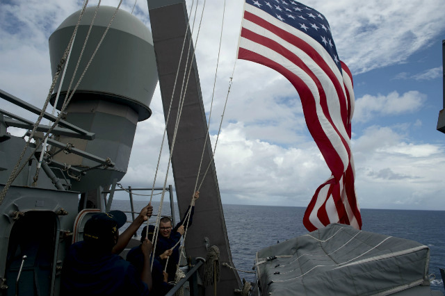 DISPUTED WATERS. In this file photo, US Navy personnel raise their flag during the bilateral maritime exercise between the Philippine Navy and US Navy dubbed Cooperation Afloat Readiness and Training (CARAT 2014) aboard the USS John S. McCain in the South China Sea near waters claimed by Beijing on June 28, 2014. Noel Celis/Pool/EPA/FIle 