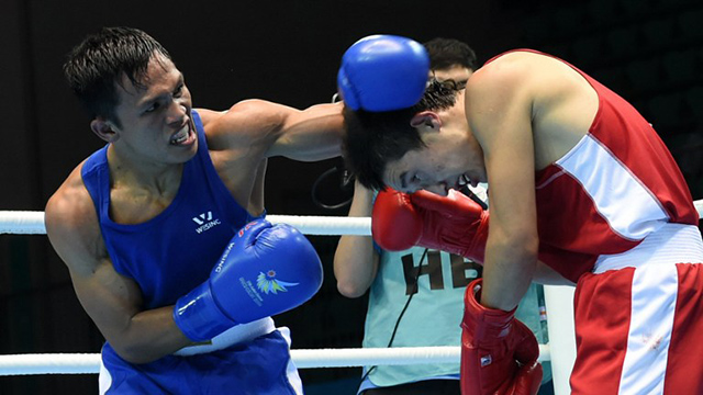 CHARLY HUSTLE. Filipino boxer Charly Suarez (L) lands a left hand on Uzekistan’s Elnur Abduraimov during the 2014 Asian Games. Suarez finished with the silver medal. File photo by Roslan Rahman/AFP 