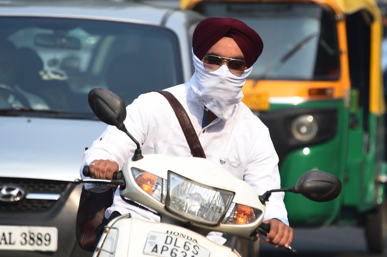 AIR POLLUTION. An Indian biker wearing face protection against air pollution rides on the road in heavy smog in New Delhi on October 28, 2016. Photo by Dominique Faget / AFP 