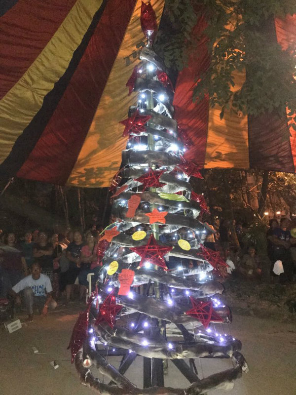 CHRISTMAS TREE. Red stars and Christmas wishes embrace the handmade branches of the tree painted in black to convey the dismay and anger of workers at the government and Sumifru.