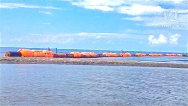 CHINESE-MARKED BUOYS. Fishermen in Zambales remove these markers seen to assert China's claim over the West Philippine Sea. Screen grab from Rappler video  