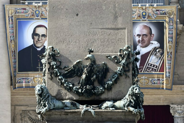 LISTO PARA LA SANTIDAD. Los tapices del Arzobispo Óscar Romero (izquierda) y del Papa Pablo VI (derecha) cuelgan de un balcón de la fachada de la Basílica de San Pedro en el Vaticano el 13 de octubre de 2018, un día antes de que la Iglesia Católica los reconozca oficialmente como santos. Foto de Filippo Monteforte/AFP 