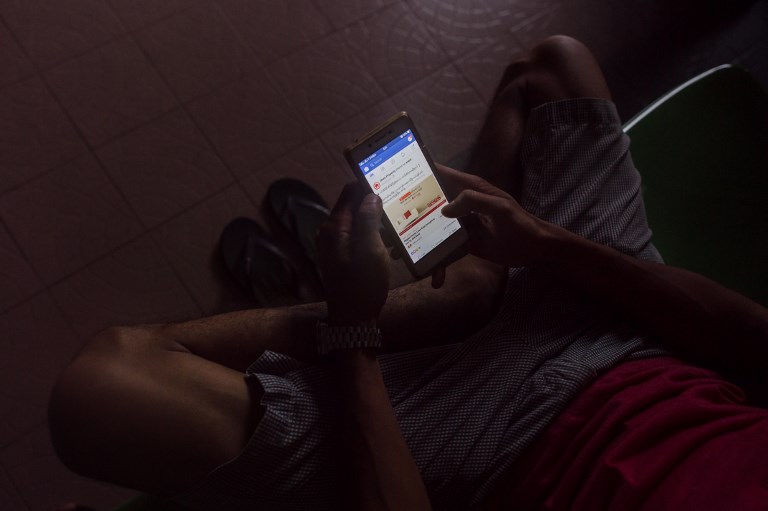 MYANMAR AND FACEBOOK. A man uses Facebook on a mobile phone in Yangon on June 7, 2018. Photo by Ye Aung Thu/AFP 