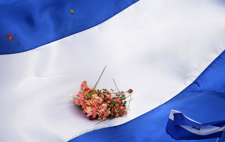 PROTEST. Flowers are seen on a Nicaraguan national flag during the "Marcha de las Flores" – in honor of the children killed during protests- in Managua on June 30, 2018. Photo by Marvin Recinos/AFP   