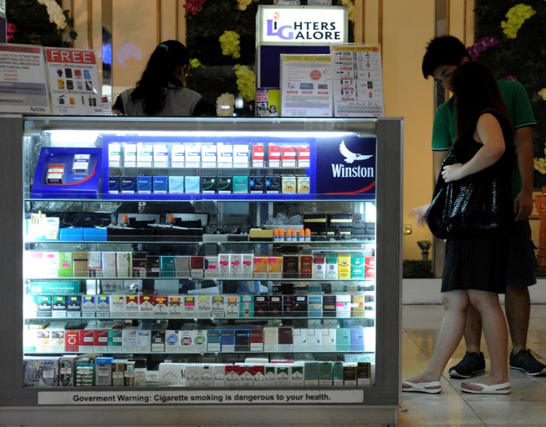MORE EXPENSIVE? Customers look at a stall selling cigarettes at a mall in Manila. File photo by Jay Directo/AFP 