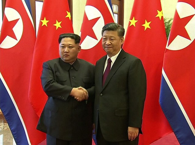 KIM'S FIRST TRIP ABROAD. This video grab taken from footage released by China Central Television (CCTV) on March 28, 2018 shows Chinese President Xi Jinping (R) and North Korean leader Kim Jong Un shaking hands during their meeting in Beijing on March 27, 2018. AFP PHOTO / CCTV 
