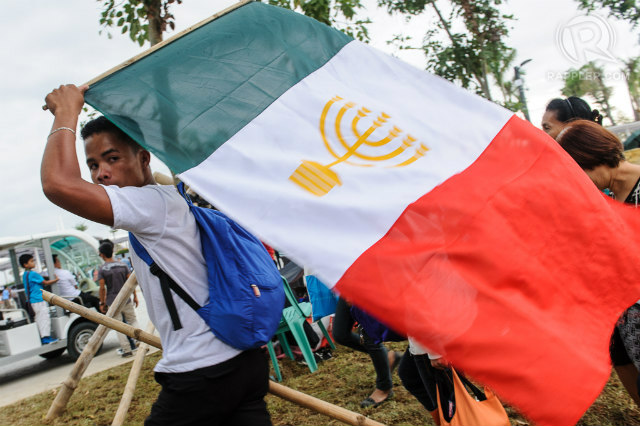 CENTURY-OLD CHURCH. A man holds the flag of the Iglesia ni Cristo during its centennial celebration in Bulacan in July 2014. File photo by Rico Cruz 