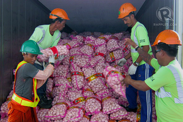 SMUGGLED GARLIC. Workers haul bags of smuggled garlic seized by the Bureau of Customs. Rappler file photo