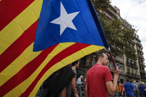 INDEPENDENCE. A man waves a Catalan pro-independence 'Estelada' flag as people march in Barcelona during a general strike in Catalonia called by Catalan unions on October 3, 2017. Photo by Pau Barrena/AFP 