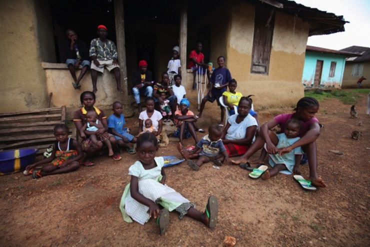 QUARANTINE. Liberians under quarantine due to the the death of more than twenty residents of their village from Ebola sit outside a house in Jene Wondi, Liberia, October 30, 2014. File photo by Ahmed Jallanzo/EPA