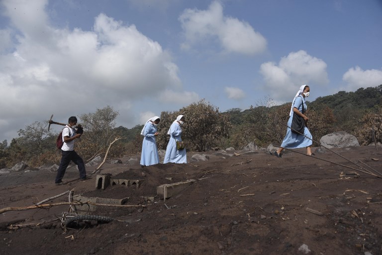 FUEGO VOLCANO. Nuns bless the disaster zone during the search for victims of the Fuego Volcano eruption, in the ash-covered village of San Miguel Los Lotes, in Escuintla Department, about 35 km southwest of Guatemala City, on June 11, 2018. Photo by Johan Ordonez/AFP 