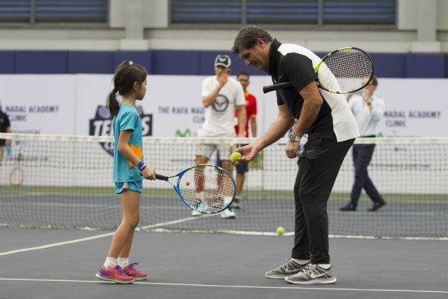 LESS-ON IS MORE. Toni Nadal, the uncle/coach of Rafael Nadal, gives a young Filipina girl an invaluable tutorial. Photo by Ena Terol/Rappler 
