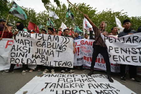 Sejumlah umat Islam dari Forum Umat Islam (FUI) Sulawesi Tengah meneriakkan yel yel saat berunjuk rasa di depan kantor Polda Sulawesi Tengah di Palu, Jumat (21/10). Foto oleh Basri Marzuki/ANTARA 