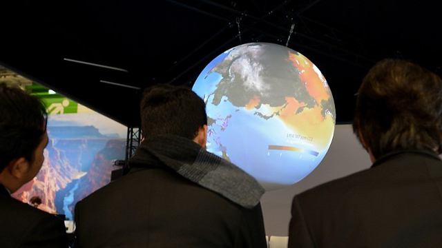CLIMATE TALKS. Visitors wait by a planisphere on the US stand at the COP21 United Nations conference on climate change, on December 4, 2015 in Le Bourget. Photo by Eric Piermont/AFP 