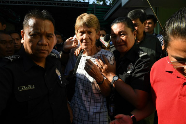 DETAINED OVERNIGHT. Australian nun Sister Patricia Fox (C) is escorted by immigration officers during her release from detention at the Bureau of Immigration in Manila on April 17, 2018, a day after she was arrested. Photo by Ted Aljibe/AFP 