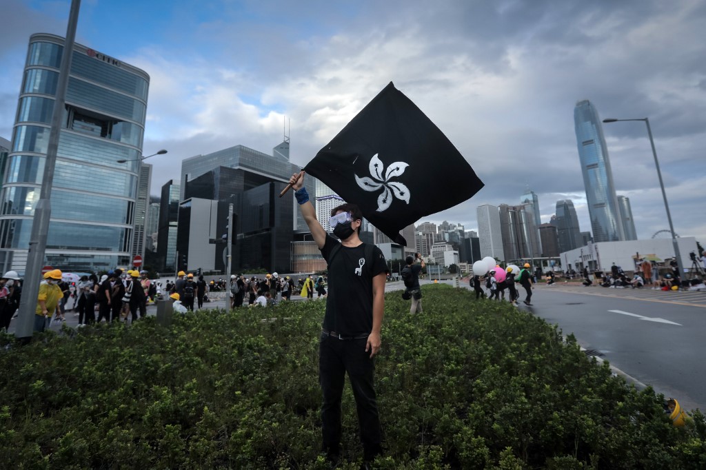DEFIANT. In this file photo taken on early July 1, 2019, a protester waves a "Black Bauhinia" flag as others set up barricades at Lung Wo road outside the Legislative Council in Hong Kong before the flag raising ceremony to mark the 22nd anniversary of handover to China. Photo by Vivek Prakash/AFP  