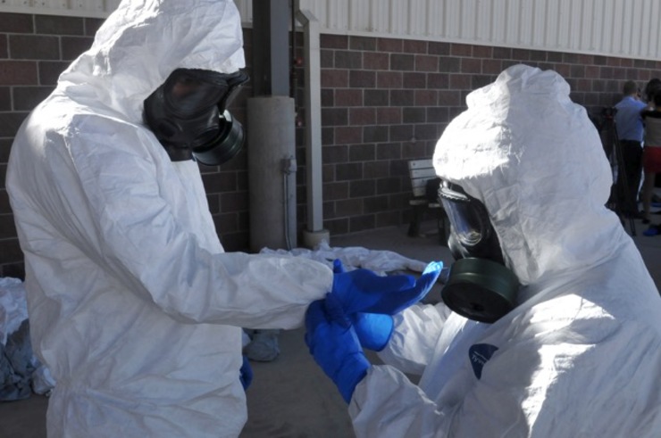 EBOLA PREPARATIONS. A handout picture released by the US Army on October 24, 2014 shows US Staff Sgt. Marquez, (R) helps Sgt. Aguilar, both horizontal construction engineers, put on a second set of latex gloves during protective suit training in Fort Carson, Colorado, USA, October 23, 2014. File photo by Jacob McDonald/US Army/EPA