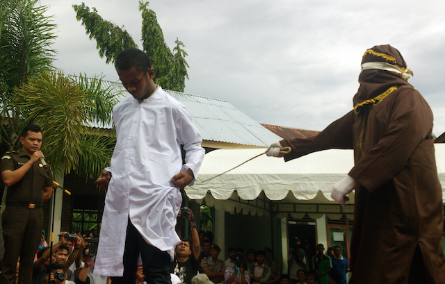 Aljogo sedang mencambuk seorang pria yang terbukti melanggar qanun syariat Islam tentang khalwat atau mesum di halaman Masjid Al Badar, Gampong Kota Baru, Banda Aceh, Jumat, 12 Juni. Foto oleh Nurdin Hasan/Rappler 