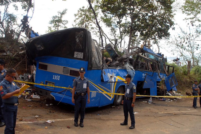 BUS CRASH. Police and soldiers stand guard next to a tourist bus which hit an electric post in Tanay town, Rizal province, east of Manila on February 20, 2017. Photo by AFP.  