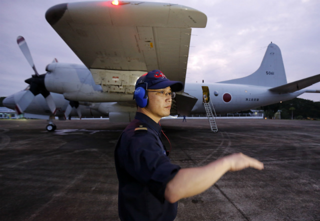 NAVAL DRILLS. A Japanese maritime self-defense force officer signals a P3C patrol plane at the Puerto Princesa airport on the island of Palawan, western Philippines, on June 24, 2015. The Philippines is holding separate naval drills with the US and Japan near the disputed South China Sea. Photo by Francis Malasig/EPA 