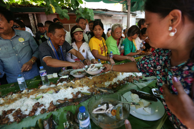 CAMPAIGN STYLE. Vice President Jejomar Binay joins Quezon residents in his favorite boodle fight. OVP photo 