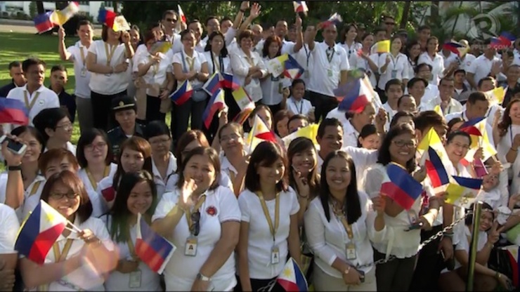 JOYFUL EVENT. Malacañang employees, some with their families, wave Philippine flags to welcome Pope Francis on January 16, 2015.
