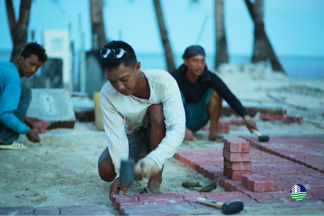 ROADWORK. Workers install bricks for the sidewalk construction along the diversion road in Barangay Balabag, Boracay. Photo from the Department of Environment and Natural Resources 