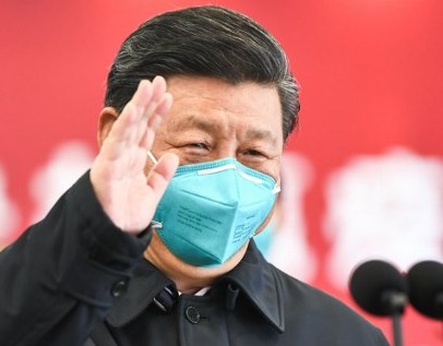 NEW NARRATIVE. This photo released on March 10, 2020 by China's Xinhua News Agency shows Chinese President Xi Jinping wearing a mask as he waves to a coronavirus patient and medical staff via a video link at the Huoshenshan hospital in Wuhan. Photo by Xie Huanchi/Xinhua/AFP  