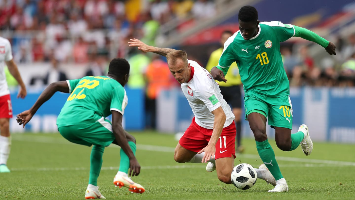 BEREBUT BOLA. Pertarungan sengit antara timnas Polandia dan Senegal berbuah kemenangan Senegal. Foto dari FIFA.com 