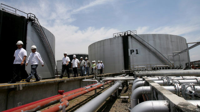 CONTROVERSIAL DEPOT. Energy officials and oil company workers inspect a biodiesel overhead tank inside the Pandacan Oil depot. File photo by Dennis Sabangan/EPA