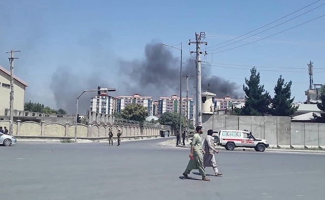 KABUL EXPLOSION. Afghan men walk on a road as smoke rises from the site of a car bomb attack in Kabul on July 1, 2019. Photo by STR / AFP 