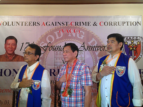 FIGHTING CRIME. Volunteers Against Crime and Corruption (VACC) founder and chairman Dante Jimenez (left), VACC auditor Arseno Evangelista (right) and Davao city Mayor Rodrigo Duterte (middle) stand for the Philippine national anthem at the start of VACC's 17 founding anniversary 