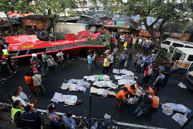 CARNAGE. Rescue workers extract the bodies of still unidentified persons from a wrecked bus that flew off the Metro Manila Skyway due to overspeeding in December, 2013. Photo by EPA/Francis Malasig   