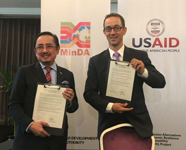 PLEDGE. MinDA Chair Datu Abul Khayr and Acting USAID Mission Director Patrick Wesner display the signed extension of the Mindanao Peace and Development Assistance Agreement. Photo from US Embassy 